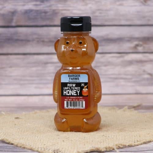 A 12oz Barger's Honey Bear, on rustic burlap with a wooden background.