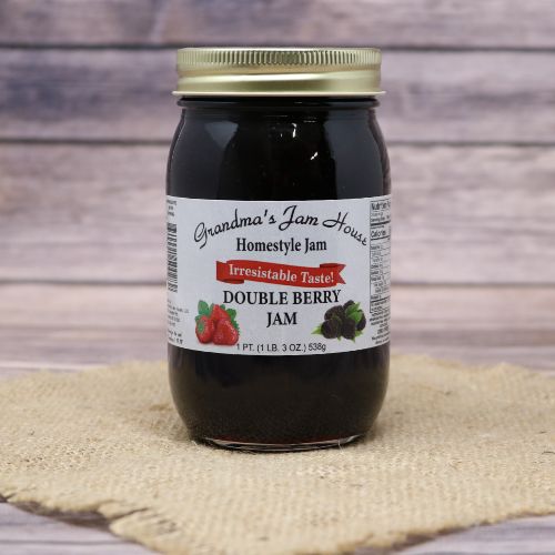 An 18oz glass jar of Grandma's Jam House Double Berry Jam, on rustic burlap with a wooden background.