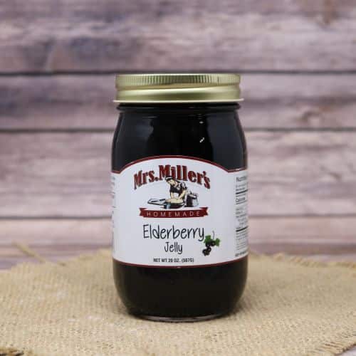 A 20oz glass jar of Mrs. Miller's Elderberry Jelly, on rustic burlap with a wooden background.