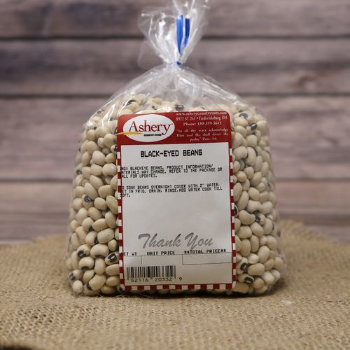 A bag of Black-Eyed Beans sealed with a twist tie, on rustic burlap with a wooden background.