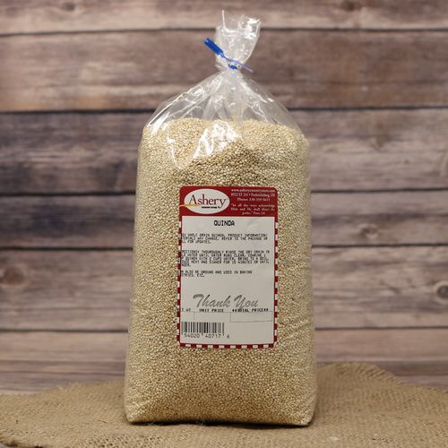 A bag of Quinoa, sealed with a twist tie, on rustic burlap with a wooden background.