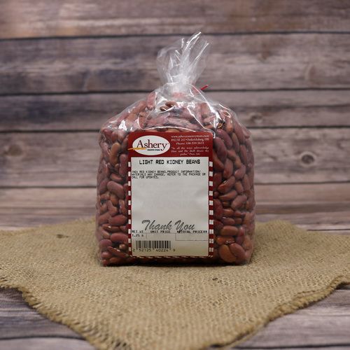 A clear plastic bag of Red Kidney Beans sealed with a twist tie on rustic burlap with a wooden background.