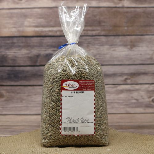 A bag of Rye Berries, sealed with a twist tie, on rustic burlap and a wooden background.