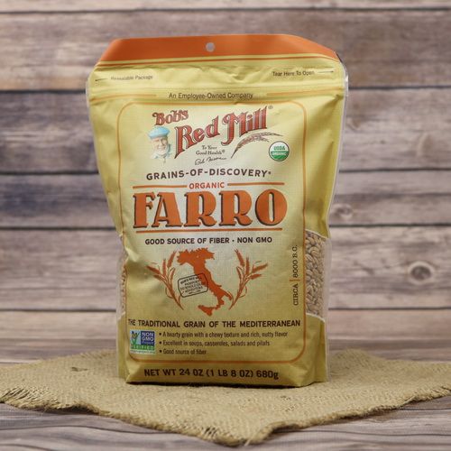 A bag of Bob's Red Mill Organic Farro Grain, on rustic burlap with a wooden background.