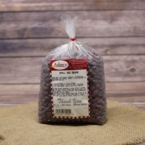 A clear plastic bag of dried Small Red Beans sealed with a twist tie on rustic burlap with a wooden background.