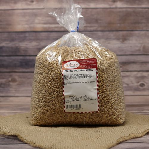 A bag of Prairie Gold Kernels, sealed with a twist tie, on rustic burlap with a wooden background.