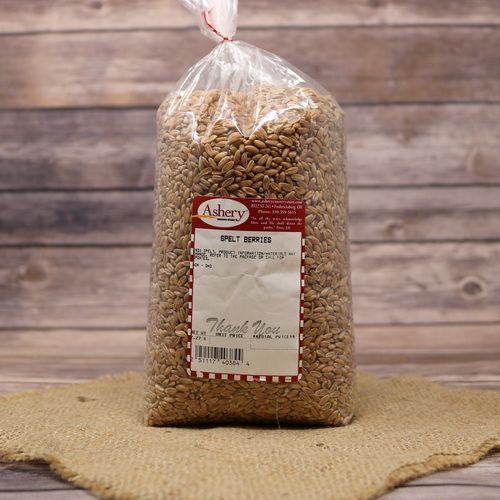 A bag of Spelt Berries, sealed with a twist tie, on rustic burlap with a wooden background.