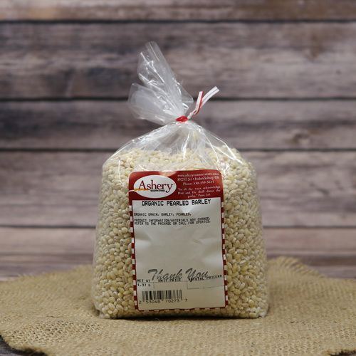 A bag of Organic Pearled Barley, sealed with a twist tie, on rustic burlap with wooden background.