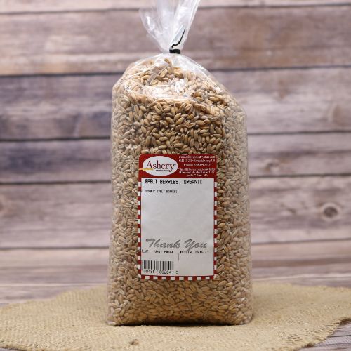 A bag of Organic Spelt Berries, sealed with a twist tie, on rustic burlap and wooden background.