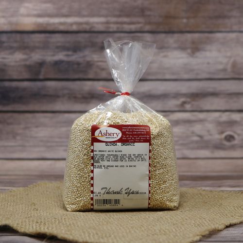 A bag of Organic Quinoa, sealed with a twist tie, on rustic burlap with wooden background.