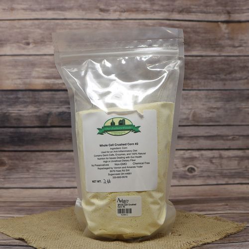 A 2 lb bag of Whole Cell Crushed Corn #2, on rustic burlap, with a wooden background.