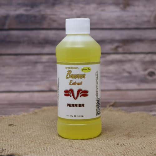 Small 8oz plastic bottle of yellow liquid with a white and green sticker label, sitting on a burlap material with wood background