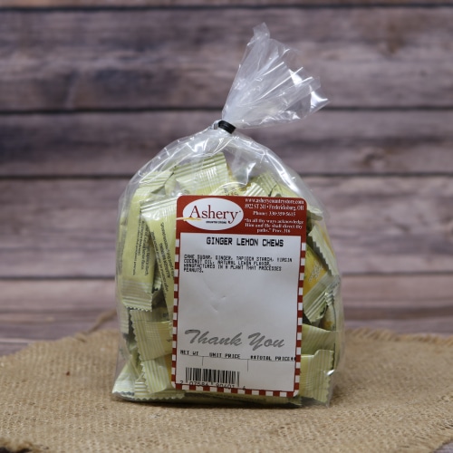 Bag of Ashery's Ginger Lemon Chews with a descriptive label, against a rustic burlap and wood background.