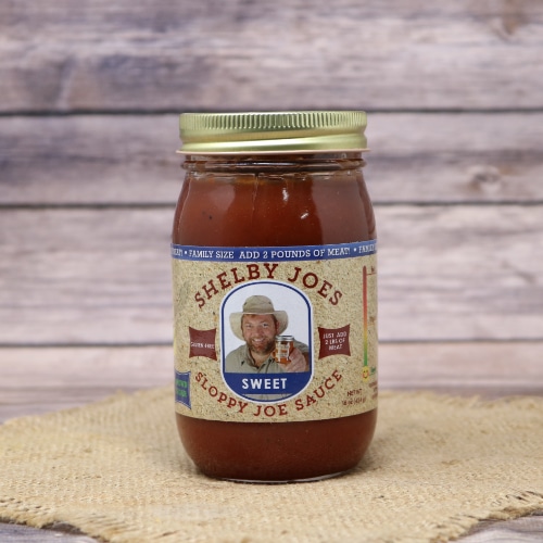 A jar of Sloppy Joe Sauce Sweet on rustic burlap and a wooden background.