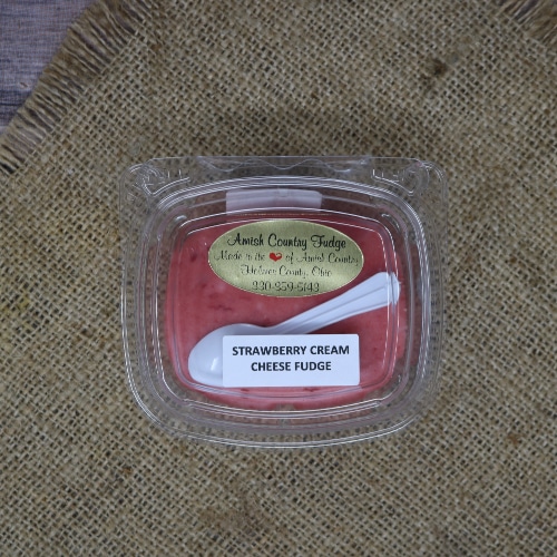 A Container of Strawberry Cream Cheese Fudge Amish Country with a small spoon on a burlap bag.