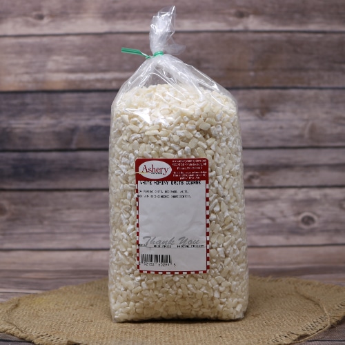 A bag of White Hominy Grits Coarse, tied with a twist tie, on rustic burlap with a wooden background.