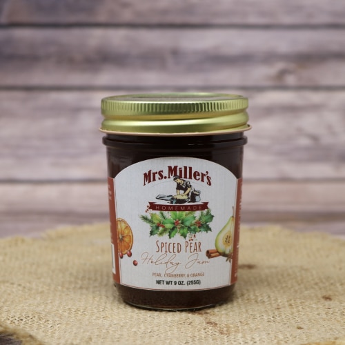 A 1/2-pint jar of Spiced Pear Holiday Jam made by Mrs. Miller's Jam on rustic burlap with a wooden background.